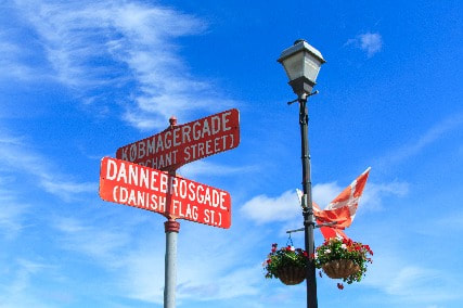 Danish American street signs in Askov, Minnesota, and a Danish flag in the background